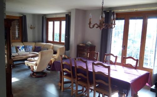une salle à manger avec une table, des chaises et un canapé dans l'établissement Villa été/hiver, à Champoulet