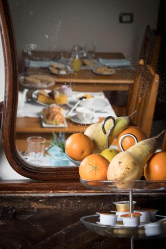 a table with plates of fruit in front of a mirror at Locanda del Borgo in Prunetto