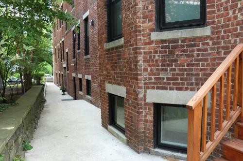 a brick building with windows and a sidewalk at A Stylish Stay w/ a Queen Bed, Heated Floors.. #15 in Brookline