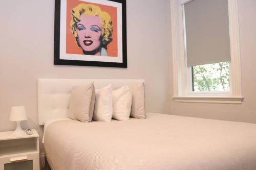 um quarto com uma cama branca e uma pintura na parede em A Stylish Stay w/ a Queen Bed, Heated Floors.. #15 em Brookline