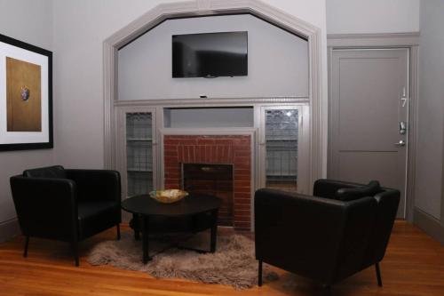 a living room with two chairs and a fireplace at A Stylish Stay w/ a Queen Bed, Heated Floors.. #15 in Brookline