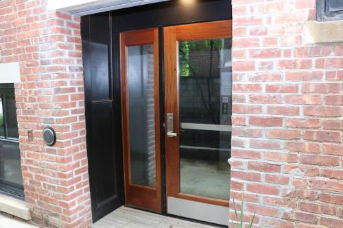 a brick building with a wooden door on it at A Stylish Stay w/ a Queen Bed, Heated Floors.. #15 in Brookline