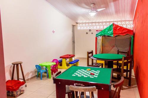 a room with tables and chairs and a table with a chessboard at Hotel Pousada Vivendas do Sol e Mar in Caraguatatuba