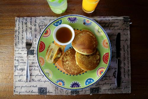 een bord pannenkoeken en een kopje koffie op een tafel bij Kaniya bali in Nusa Dua