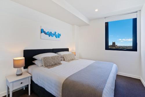 A bed or beds in a room at Beau Monde Apartments Newcastle - Horizon Newcastle Beach