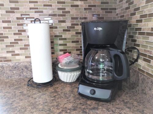 a coffee maker and a roll of paper towels on a counter at Lake Powell Motel & Apartments in Page