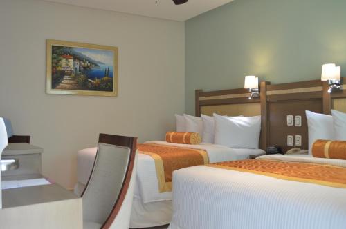 a hotel room with two beds and a picture on the wall at hotel villa magna poza rica in Poza Rica de Hidalgo