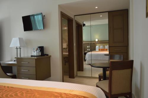 a hotel room with a bedroom with a bed and a table at hotel villa magna poza rica in Poza Rica de Hidalgo