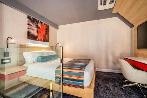 a bedroom with a bed and a desk and a chair at Century Park Hotel LA in Los Angeles