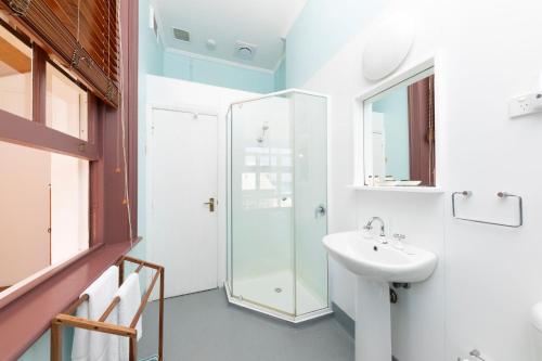 a bathroom with a sink and a shower at Seal Rocks Lighthouse Cottages in Seal Rocks