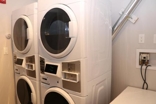 a white laundry room with two washer and dryer at A Stylish Stay w/ a Queen Bed, Heated Floors.. #36 in Brookline