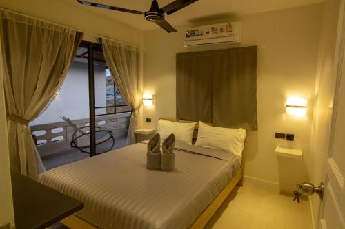 ラマイにあるAussieland Bungalowsのベッドルーム1室(靴付きのベッド1台付)
