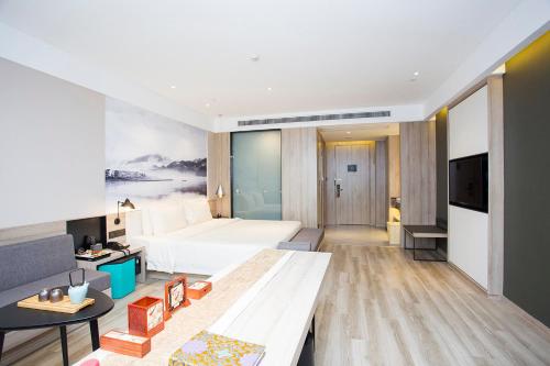 pokój hotelowy z łóżkiem i kanapą w obiekcie Atour Hotel Hangzhou Jinsha Lake w mieście Hangzhou
