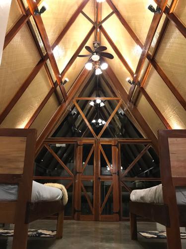 a room with a ceiling fan and two chairs at Dahun Villas Siargao in General Luna