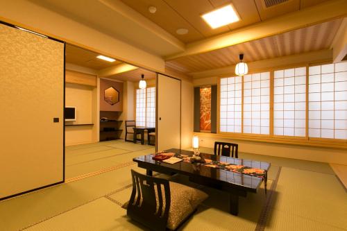 a japanese room with a table and a hallway at Matsui Honkan in Kyoto