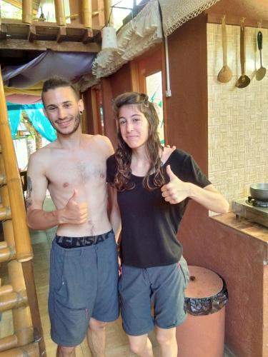 a man and a woman standing in a kitchen at Darpins Guesthouse in Dauin
