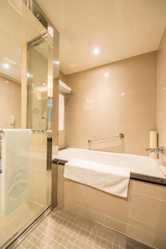 a bathroom with a bath tub and a shower at Taichung Harbor Hotel in Wuqi