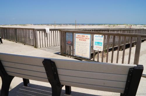 a bench sitting on a boardwalk at the beach at Beau Rivage Beach Resort in Wildwood Crest