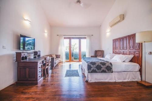 a bedroom with a bed and a desk and a television at Kandy Casa by Regus in Kandy