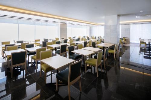 a dining room with tables and chairs and windows at Kyoto U-BELL Hotel in Kyoto