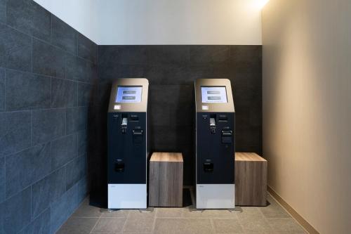 two atm machines in a restroom with a wall at Kyoto U-BELL Hotel in Kyoto