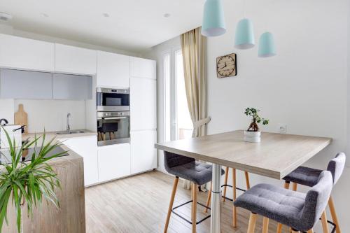 une cuisine et une salle à manger avec une table et des chaises en bois dans l'établissement L'Amandine ,45 m2 terrasse et garage centre ville, à Saint-Raphaël