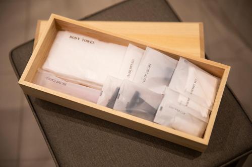 a wooden box filled with white papers on a chair at Kyoto U-BELL Hotel in Kyoto