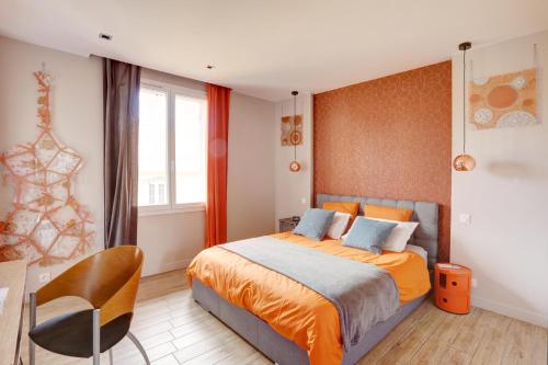 - une chambre avec un lit king-size et une chaise dans l'établissement L'Amandine ,45 m2 terrasse et garage centre ville, à Saint-Raphaël