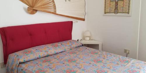1 cama con cabecero rojo en un dormitorio en N207 - Numana, deliziosa villetta con giardino, en Numana