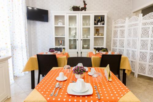 a dining room with tables and chairs with orange table cloth at A casa di Simona in Monreale