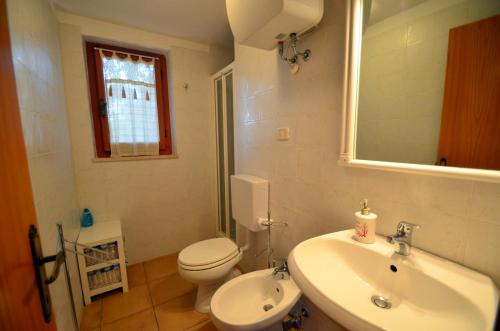 a bathroom with a white toilet and a sink at Villette Luisa by SolturElba in Capoliveri