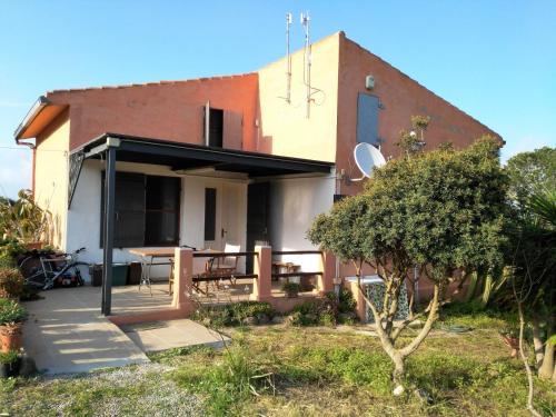 a house with a patio and a table in front of it at Agriturismo Glamping Erbe Matte in SantʼAntìoco