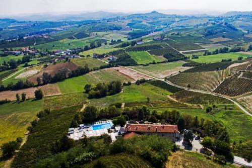 an estate in a vineyard with a house on a hill at Locanda del Boscogrande in Montegrosso dʼAsti