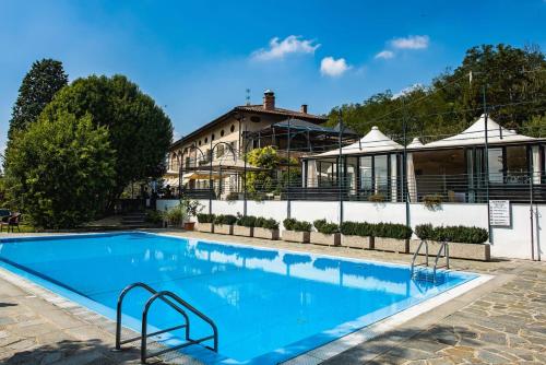 a large swimming pool in front of a building at Locanda del Boscogrande in Montegrosso dʼAsti