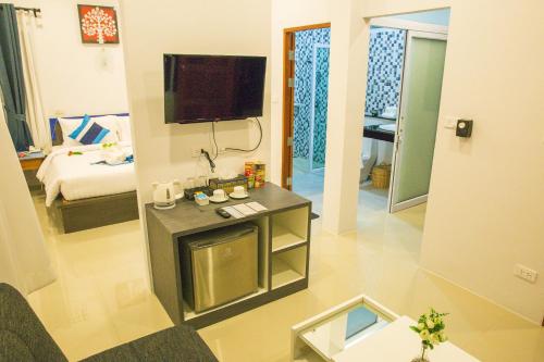 uma sala de estar com televisão e um quarto com cama em Adarin Beach Resort em Mae Nam