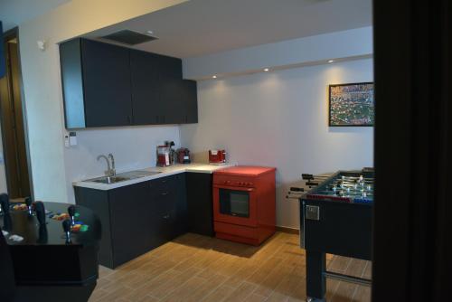 a kitchen with black cabinets and a red stove at Giannis Playroom in Kounoupidhianá