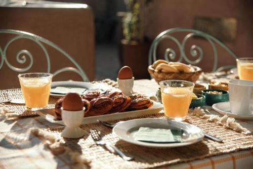 a table with a plate of food and eggs and drinks at Riad Albatoul in Marrakech