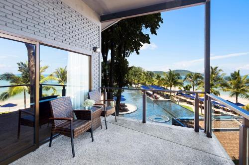 balcón con vistas a la piscina y a las palmeras en Beyond Krabi, en Klong Muang Beach