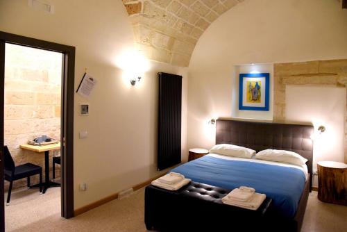 a bedroom with a bed and a table in a room at La Monaca Salentina in Lecce