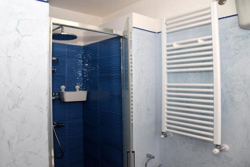 a bathroom with a shower with blue tiles at La Monaca Salentina in Lecce