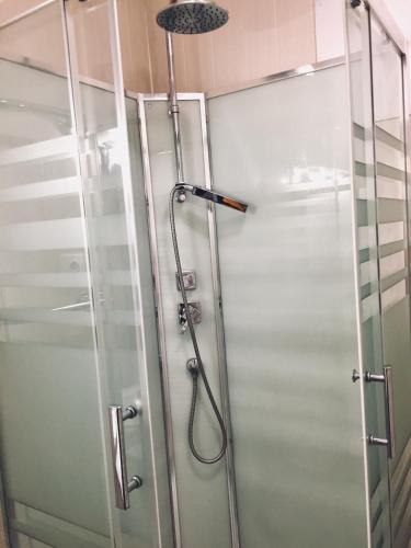 une douche dans une salle de bain avec une porte vitrée dans l'établissement Villa Bigorra Lourdes centre Le Sanctuaire La Grotte , parking, à Lourdes