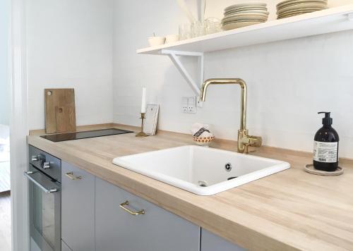 um balcão de cozinha com um lavatório branco e uma garrafa de vinho em Boes Bed & Breakfast em Skanderborg