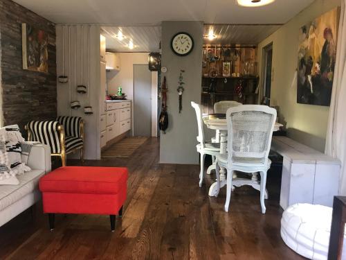 a living room with a table and chairs at Kunstenaars Boshuisje Veluwe in Hoenderloo