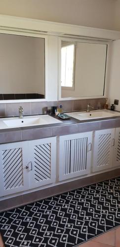 une salle de bain avec deux lavabos et deux miroirs dans l'établissement GRANDE MAISON - PISCINE - CALME - AIX EN PROVENCE, à Éguilles