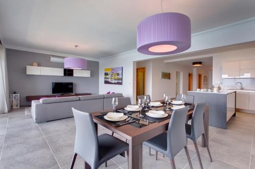 a dining room and living room with a table and chairs at Seafront Apartment Sliema in Sliema