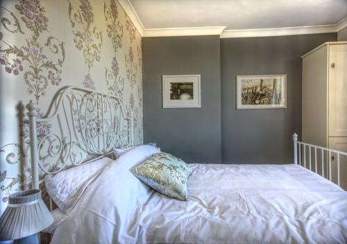 a bedroom with a white bed with a pillow on it at Seagulls Nest in Hastings
