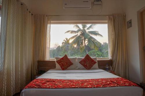 a bedroom with a bed with a window with a palm tree at Willow Heights in Athirappilly
