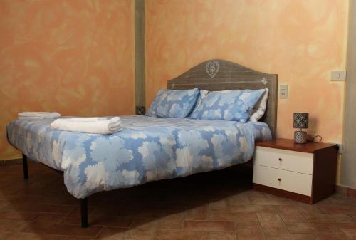 Schlafzimmer mit einem Bett mit blauer und weißer Bettwäsche in der Unterkunft Toskana Relax in Fucecchio