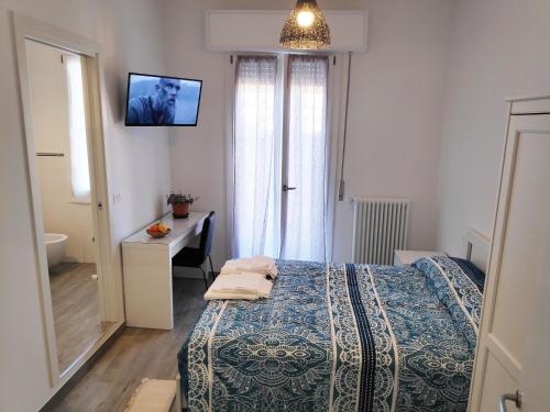 una camera da letto con un letto, una scrivania e una finestra di Casadei Guest House Stazione Bologna a Bologna