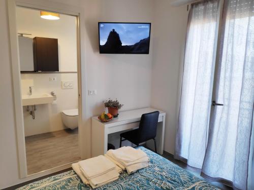 Schlafzimmer mit einem Bett, einem Schreibtisch und einem Spiegel in der Unterkunft Casadei Guest House Stazione Bologna in Bologna